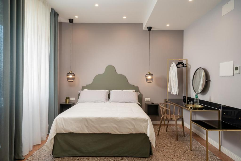 a bedroom with a large bed and a mirror at NUE SUITES in Sassari