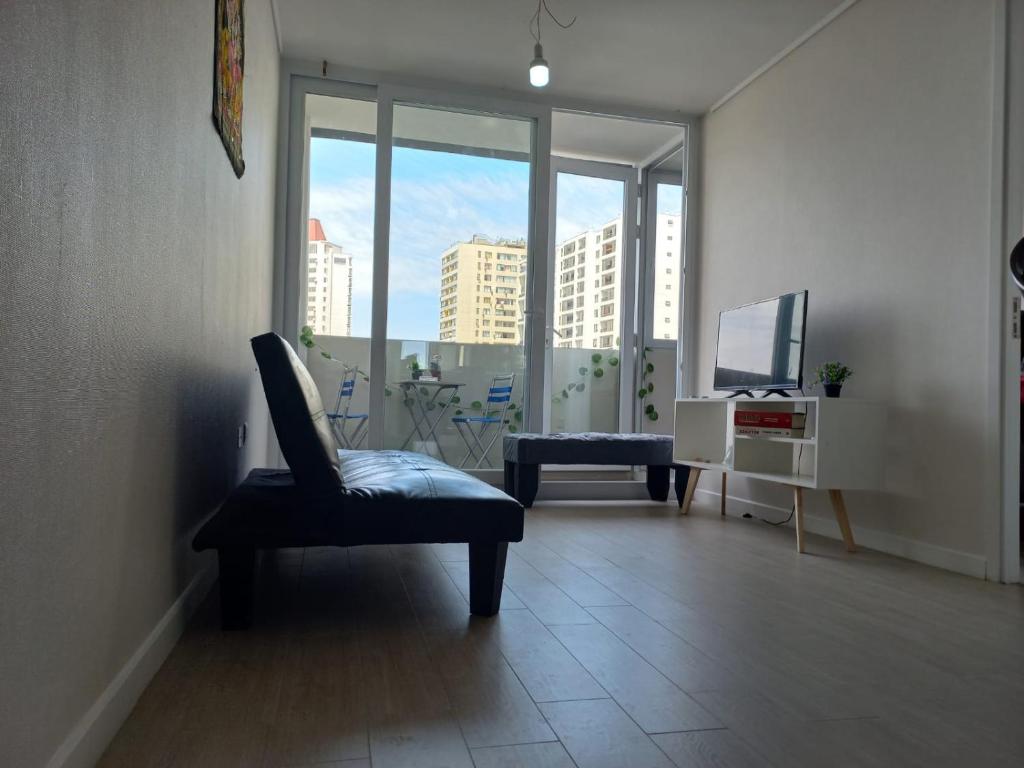een woonkamer met een stoel en een televisie bij Departamento nuevo en pleno centro de Santiago in Santiago