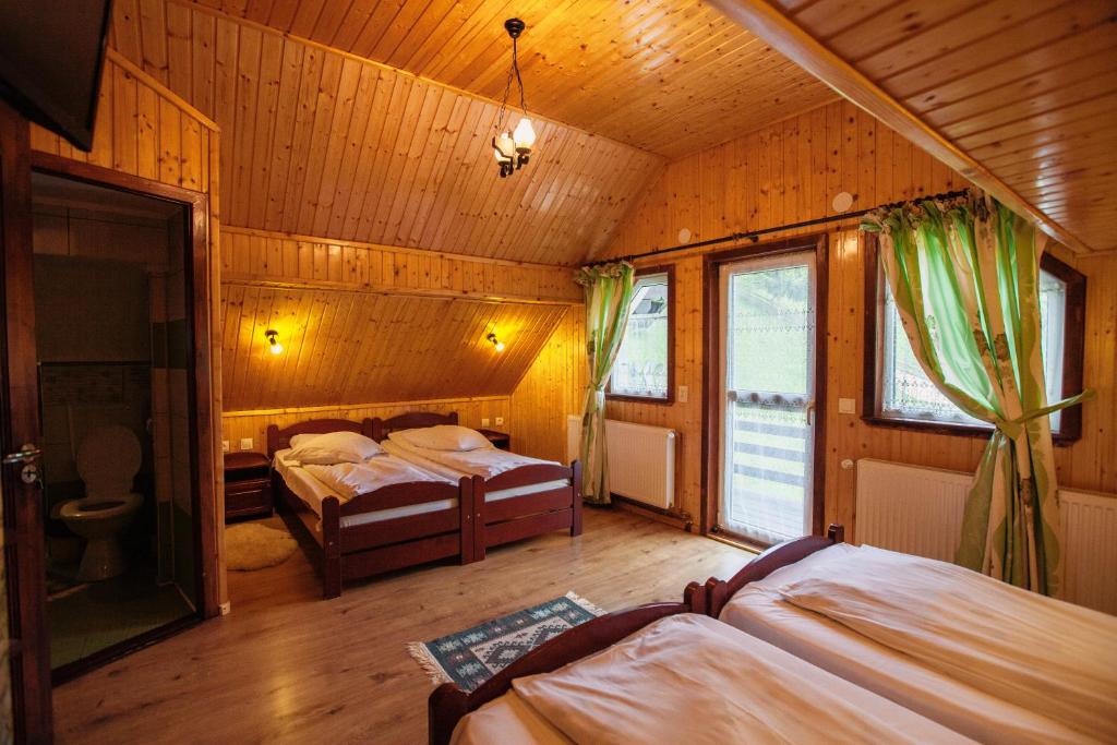 En eller flere senge i et værelse på Pensiunea Poienita Ursului