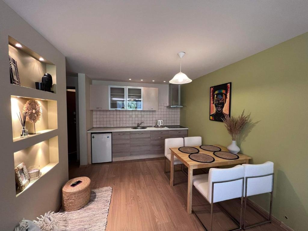 a kitchen and dining room with a table and chairs at Apartamentai Forest green in Nida