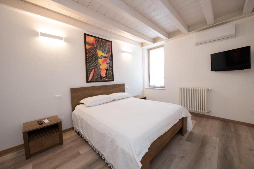Schlafzimmer mit einem Bett und einem Flachbild-TV in der Unterkunft Appartamento Al Campanile in Montinelle