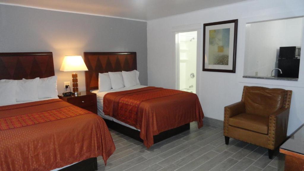 una habitación de hotel con 2 camas y una silla en ECONOMY INN, en Brownfield