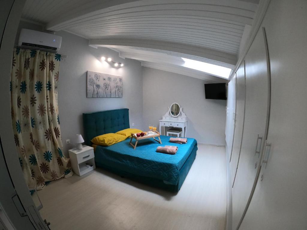 - une petite chambre avec un lit bleu et un miroir dans l'établissement CASA MARIA, à Corfou