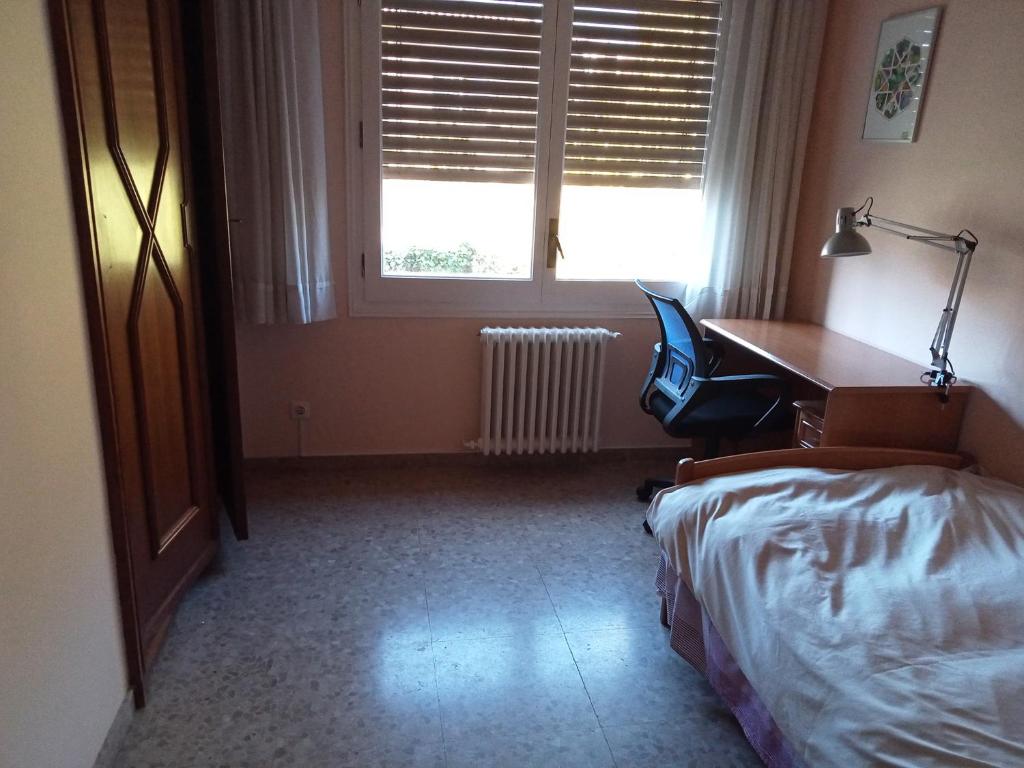 a bedroom with a desk and a bed and a desk and a chair at Habitació S Cal Kim in Martorell