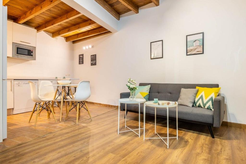sala de estar con sofá y mesa en Apartamento Macarena, en el Centro de Sevilla, en Sevilla