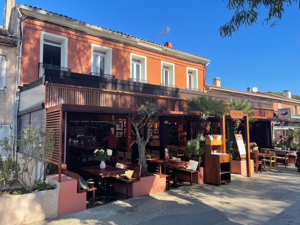 een restaurant met tafels en stoelen voor een gebouw bij L'Oustaou De Porquerolles in Porquerolles