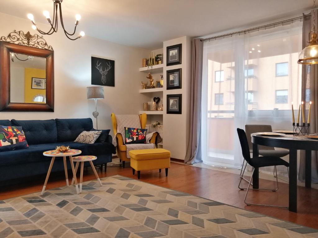 a living room with a blue couch and a table at Orange Water Apartment in Gdańsk