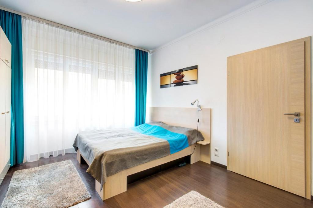 a bedroom with a bed and a large window at Károlyi street - central location quiet place 2ppl in Budapest