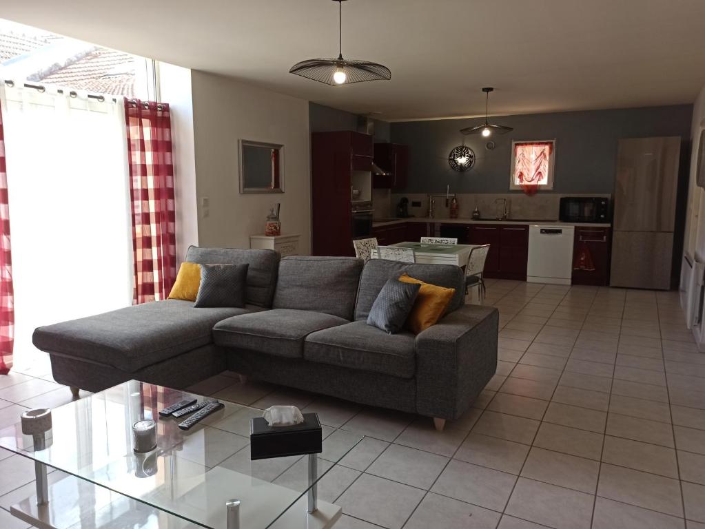 a living room with a couch and a kitchen at Joss Nath homes in Melun