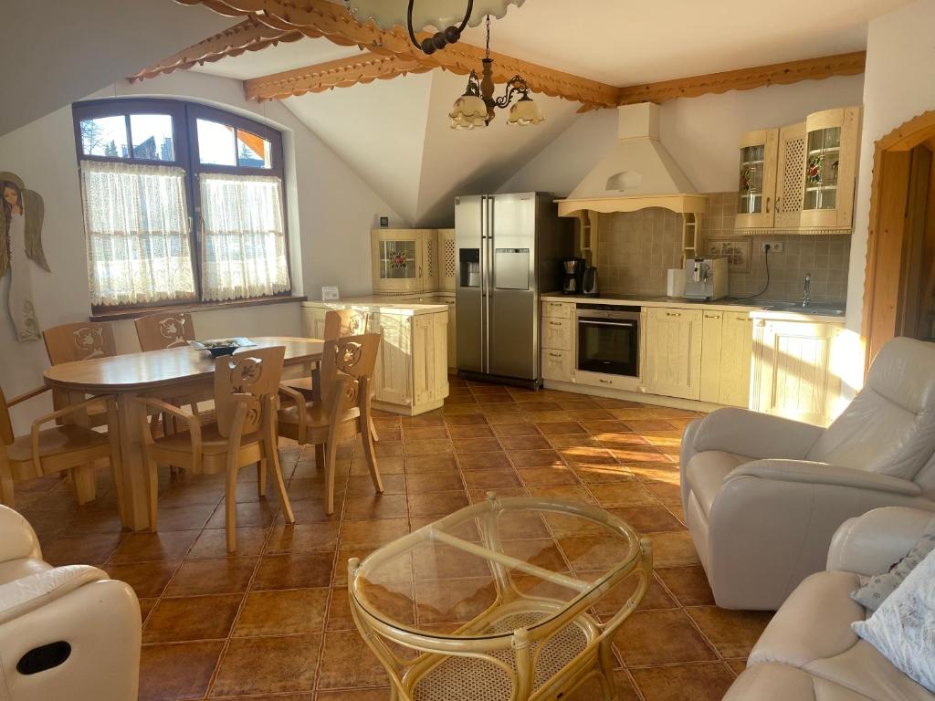 a kitchen and living room with a table and chairs at Apartament Intol z widokiem na Śnieżkę in Karpacz