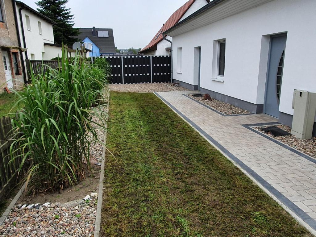 a driveway of a house with a fence at ***FeWo Am Achterwasser *** in Lütow