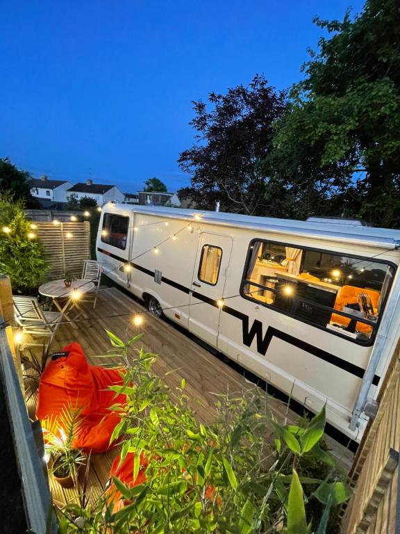 una caravana blanca estacionada en un patio por la noche en Vintage 1980s Winnebago, en Oxford