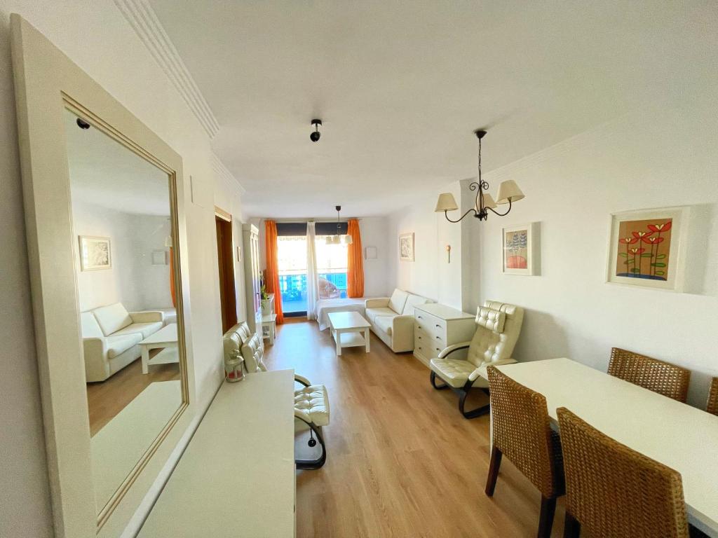 een woonkamer met een tafel en stoelen en een woonkamer bij Amplio apartamento en La Cala in Cala de Finestrat