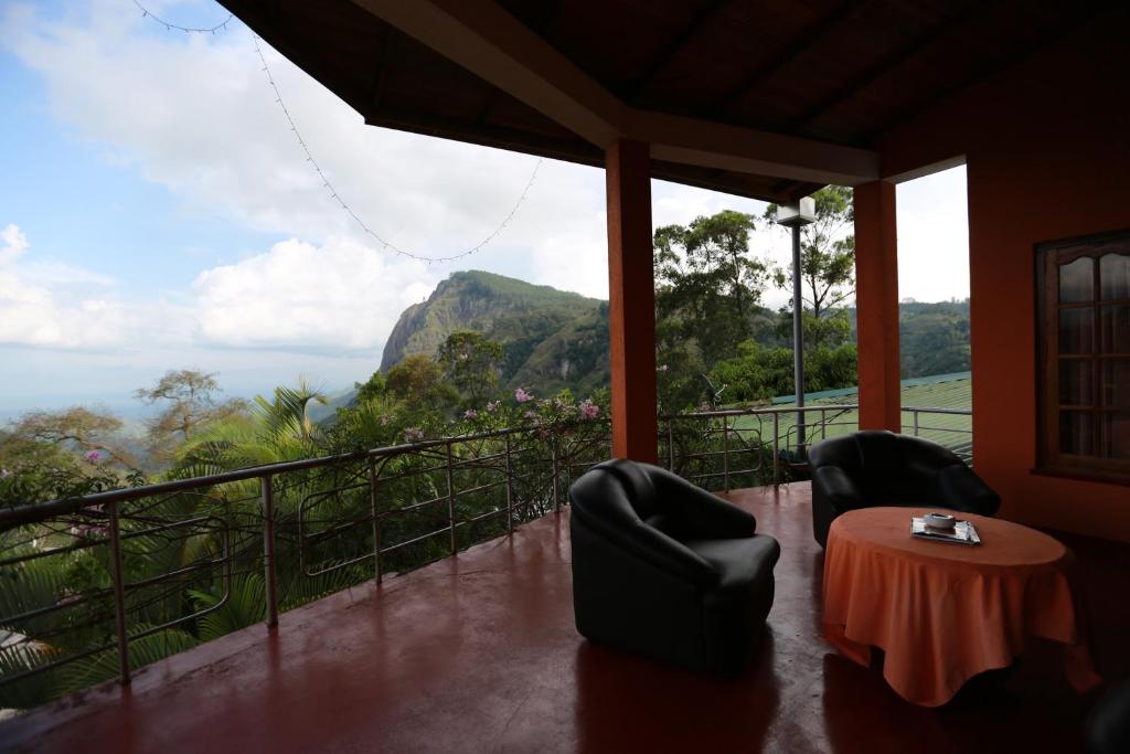 a balcony with two chairs and a table with a view at Tea Garden Holiday Inn in Ella