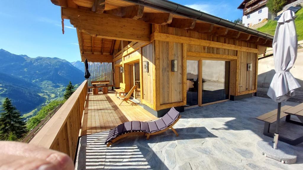 a house with a balcony with a view of mountains at Panorama Berg Chalet in Großkirchheim