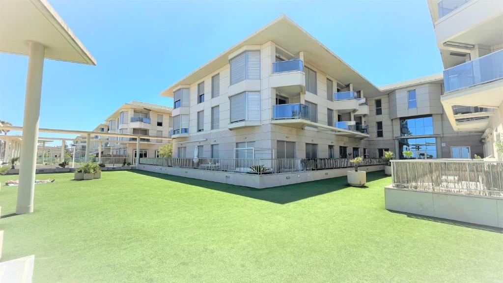 un gran edificio de apartamentos con césped delante en BEACH VALENCIA 21 - Luxury Apartament on Beach, en Valencia