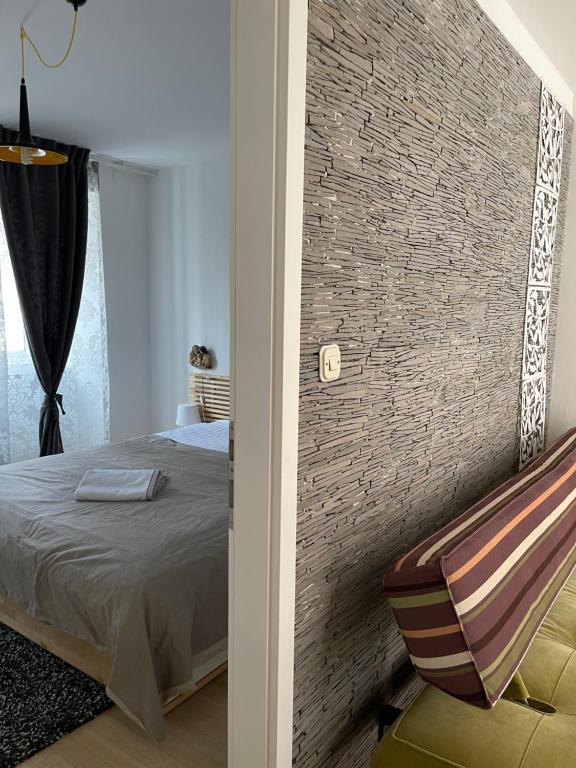 een slaapkamer met een bed en een bakstenen muur bij Apartments Kremenic in Cres