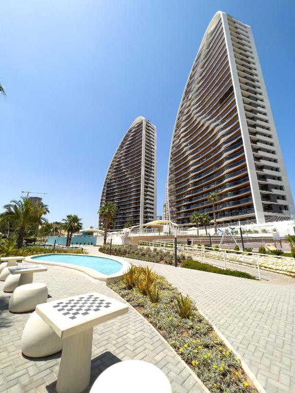 two tall buildings and a swimming pool with two buildings at Sunset Waves 3 Benidorm in Benidorm
