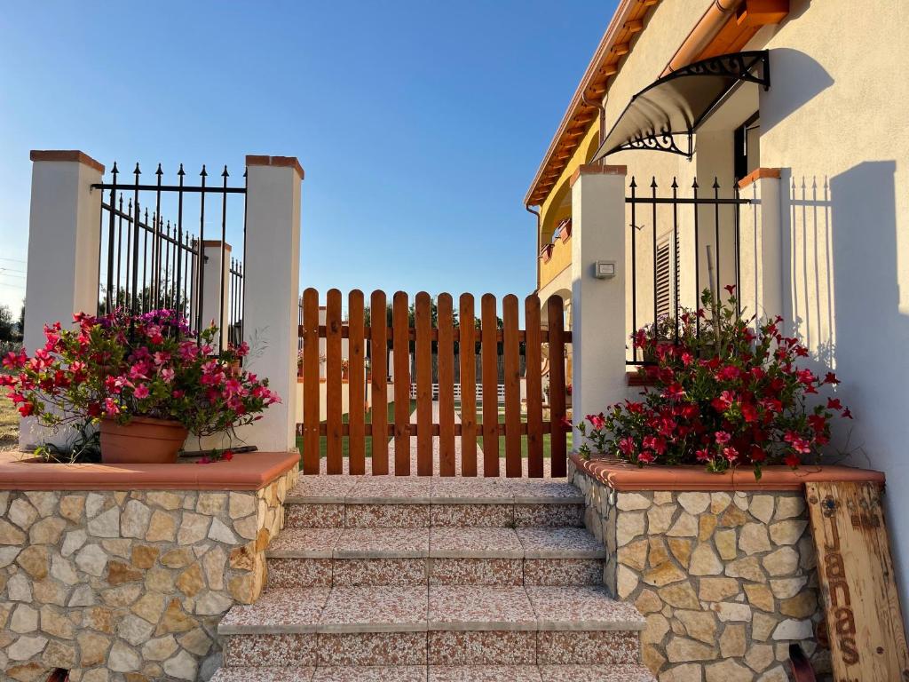 ein Haus mit einem Tor und einer Treppe mit Blumen in der Unterkunft Janas B&B in Posada