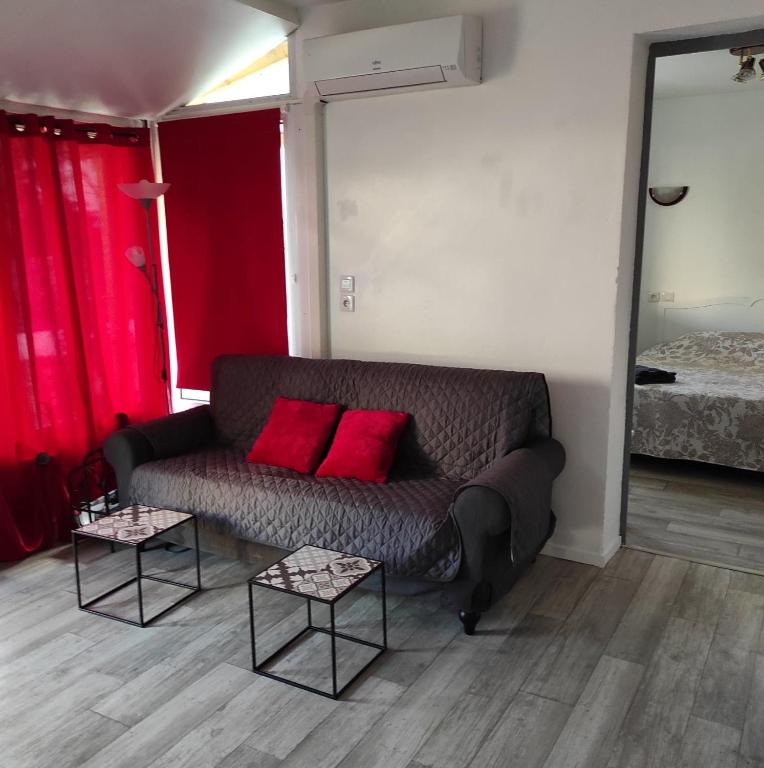 uma sala de estar com um sofá e duas mesas em studio 30m2 em Arles