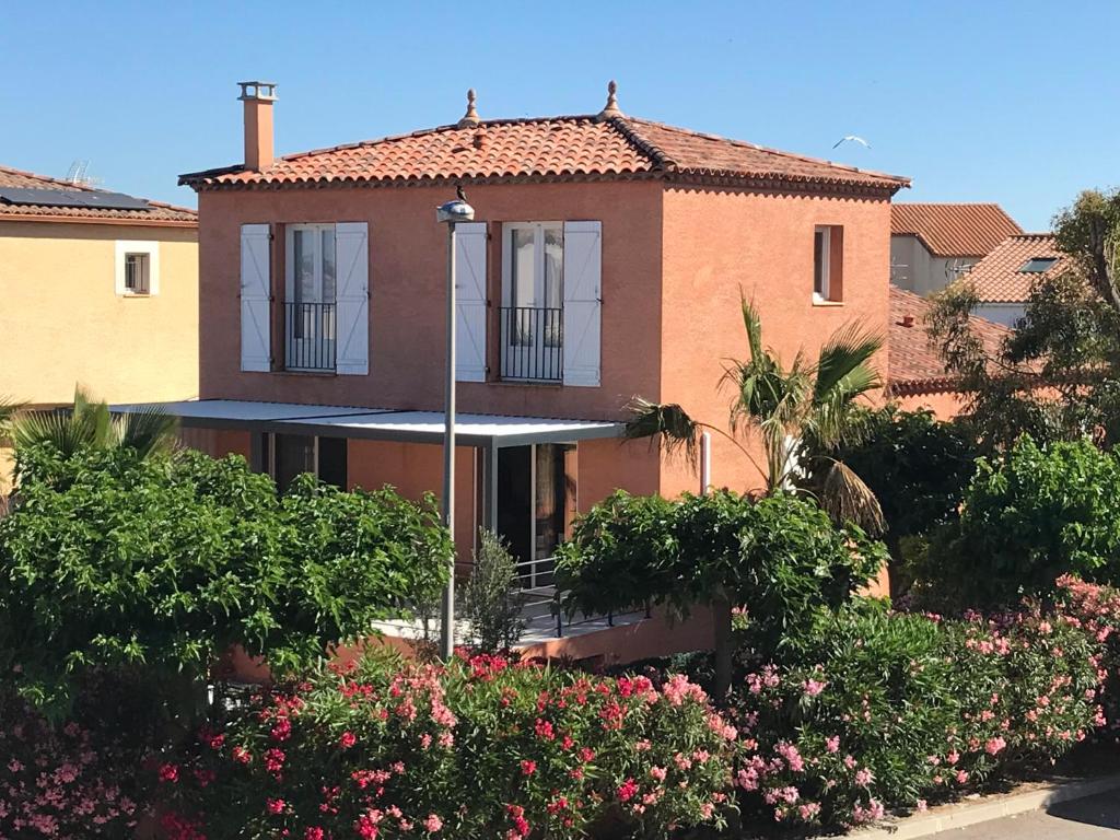 une maison avec des fleurs devant dans l'établissement Villa Mer classée, à 3 mn à pied de la plage, à Frontignan