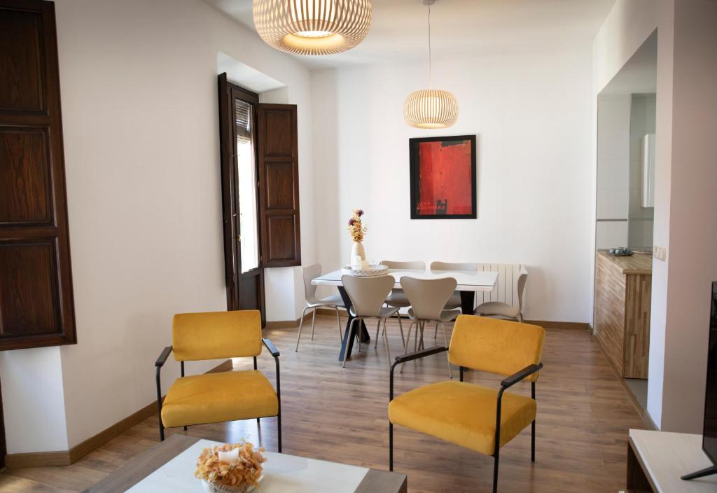Apartamento Lomeña في غرناطة: غرفة طعام بها طاولة وكراسي