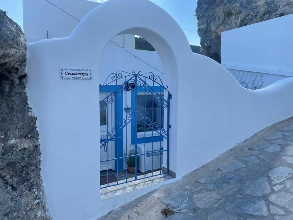 una puerta azul en el lateral de un edificio en Ονειρόπετρα Λέρος~Oneiropetra Leros, en Panteli