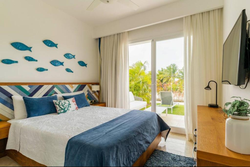 ein Schlafzimmer mit einem Bett und einem großen Fenster mit Fisch an der Wand in der Unterkunft Apartamento Acceso Directo a la piscina A-108, A-120, A-117 y B-137 in Punta Cana