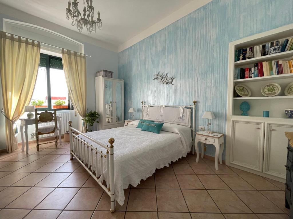 - une chambre avec un lit blanc et un mur bleu dans l'établissement A casa di Stella, à Salerne