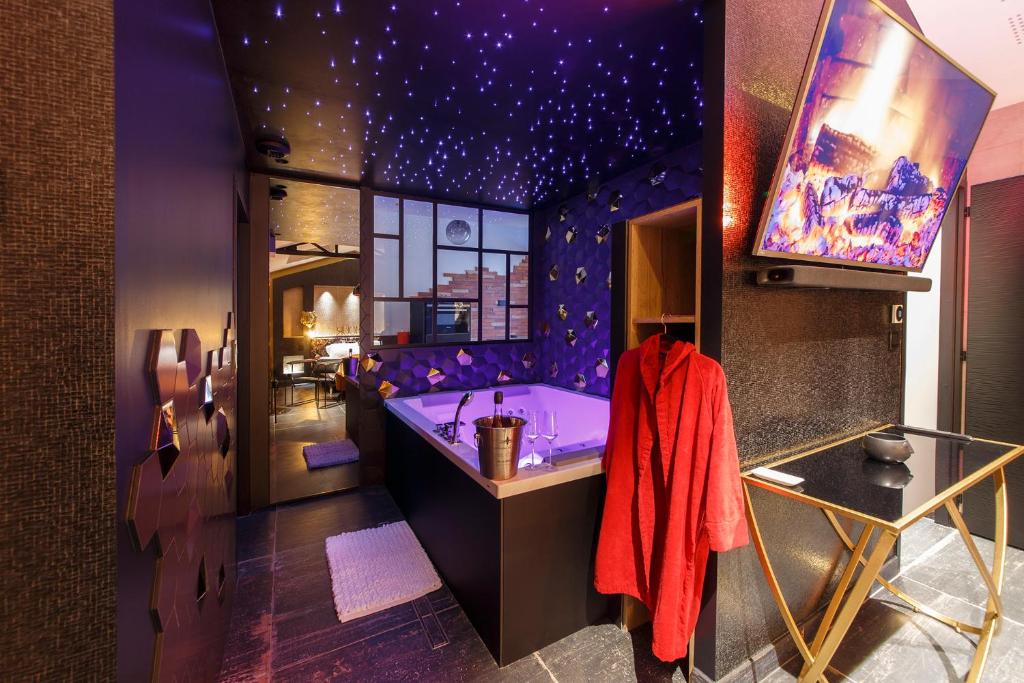 uma casa de banho roxa com uma banheira e um tecto de estrelas em Loft Room 85, petite maison avec jacuzzi privatif em Les Sables-dʼOlonne