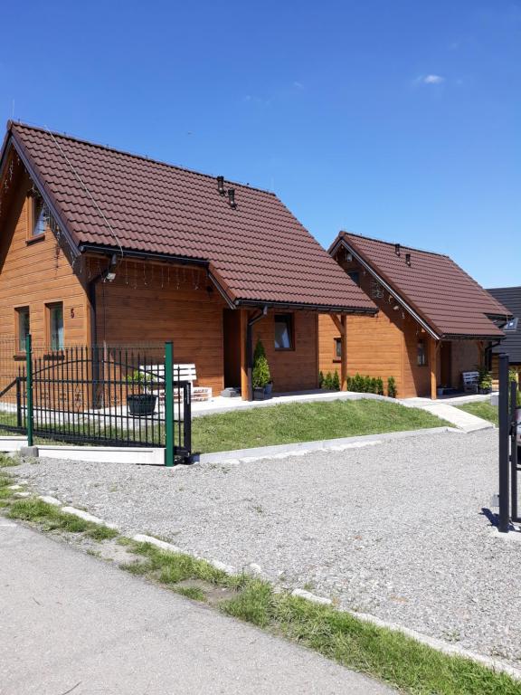 ein Haus mit einem Zaun davor in der Unterkunft Nowe domki w górach "Pod Skrzycznym", koło Szczyrku in Szczyrk