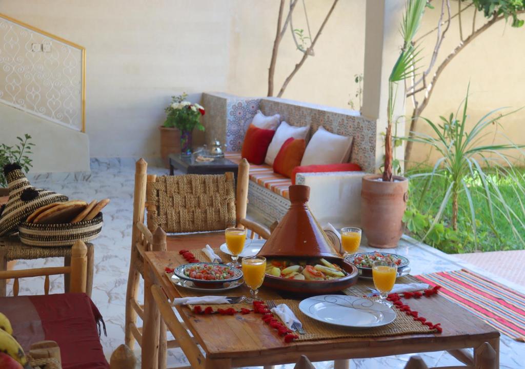 einen Tisch mit Essen und Getränken auf dem Sofa in der Unterkunft villa saada in Marrakesch