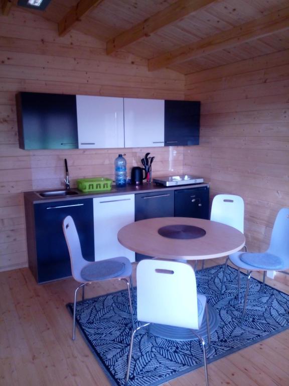 a kitchen with a table and chairs in a room at Fioletowy in Niechorze