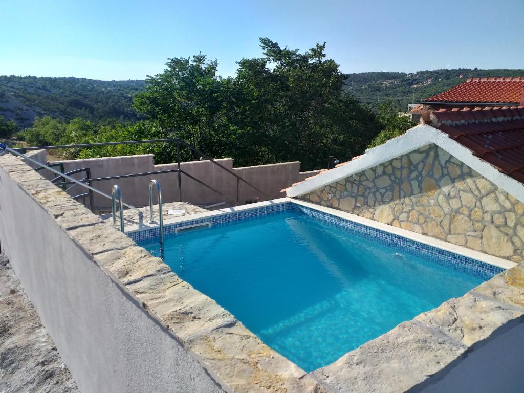 a swimming pool on the side of a house at House Milovic in Skradin