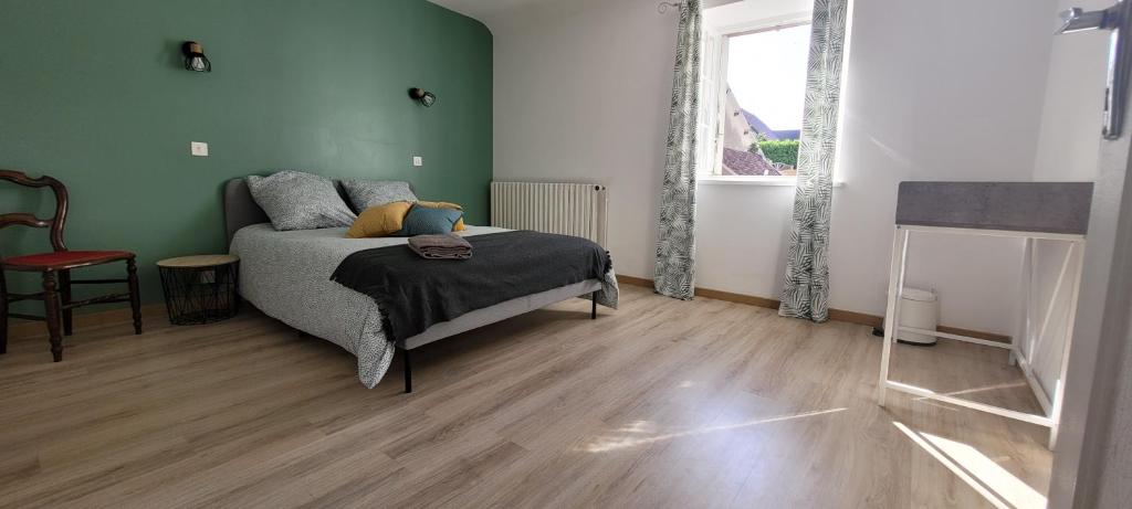 a bedroom with a bed and a green wall at Le Domaine du Bien-Être in Rahon