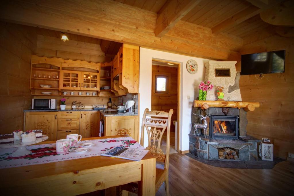 Cabaña con cocina con mesa y fogones. en Domki i Apartamenty Krupa Ciche, en Zakopane