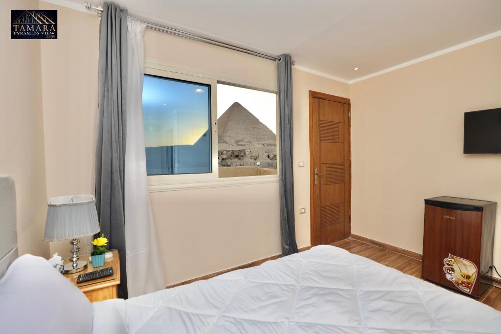Een bed of bedden in een kamer bij Tamara Pyramids View