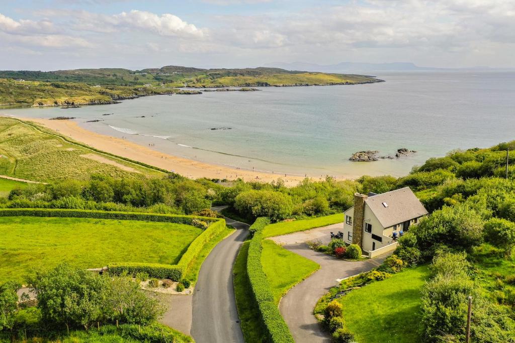 eine Luftansicht auf ein Haus und einen Strand in der Unterkunft Fintra Beach B&B in Donegal