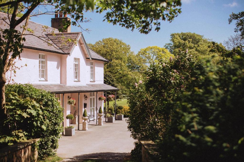 uma entrada que leva a uma casa branca em Plas Dinas Country House em Caernarfon