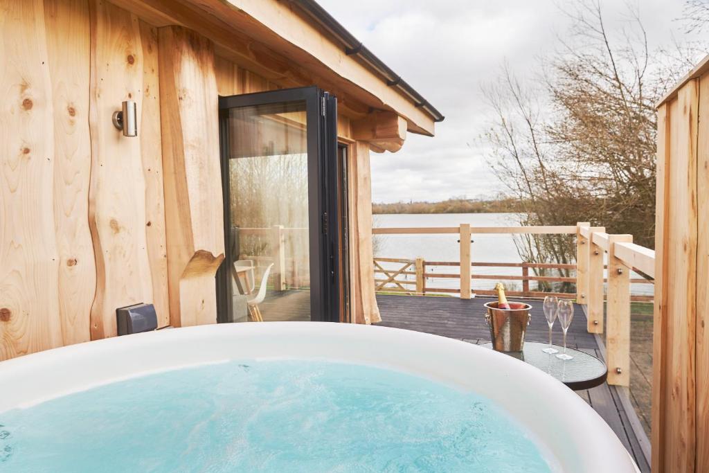 a bath tub sitting in front of a wooden house at Waters Edge Retreat in Naseby