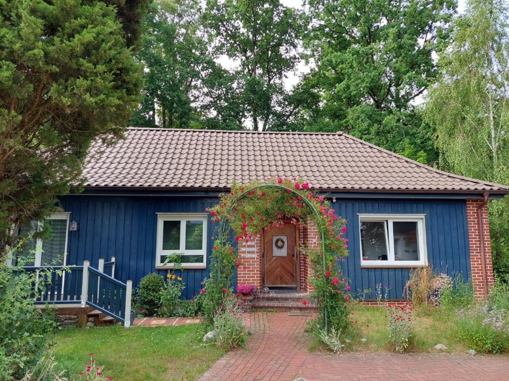 a blue tiny house with areath of flowers in front of it at Ferienwohnung Am Freitagsbach in Celle