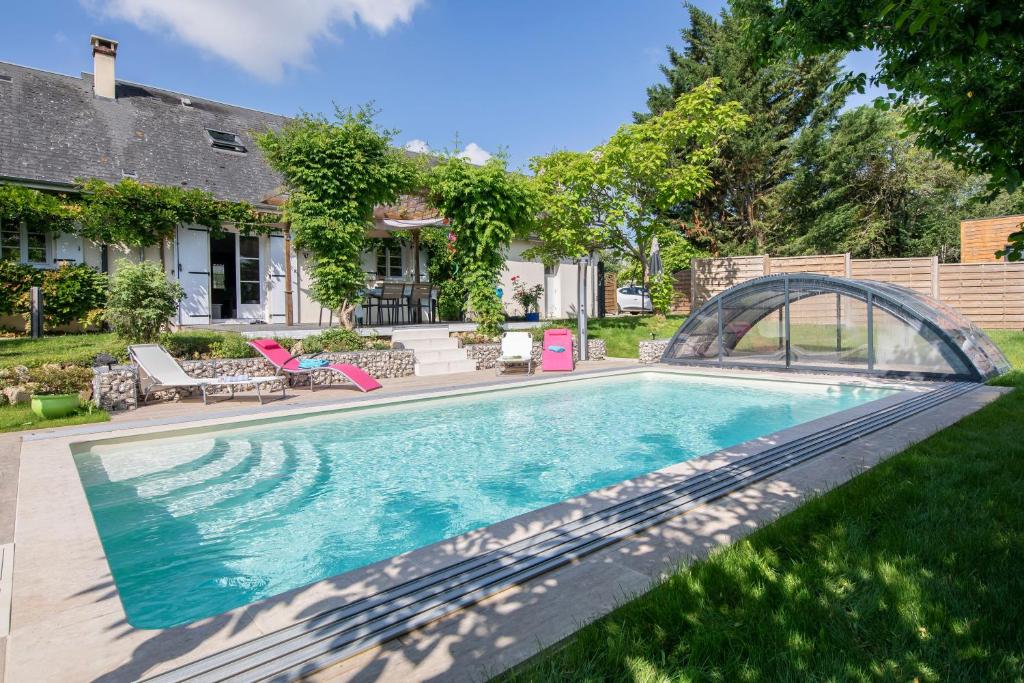 Au Coeur du Bien-Etre, chalet avec piscine chauffée et couverte, SPA, sauna, massages في Monteaux: مسبح في ساحة منزل