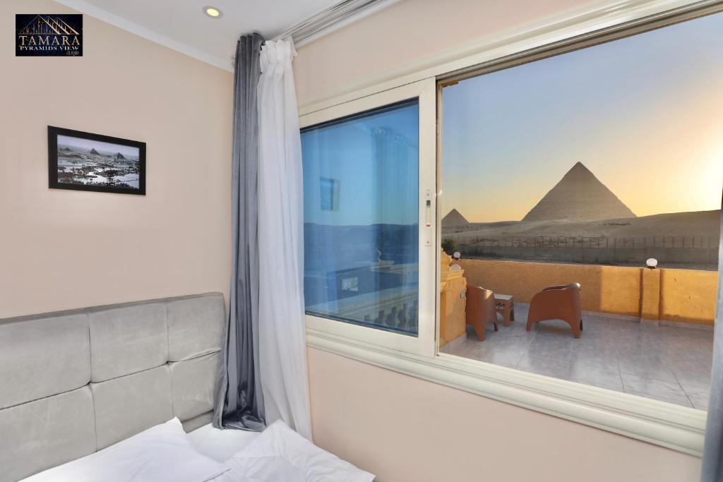 Een bed of bedden in een kamer bij Tamara Pyramids View