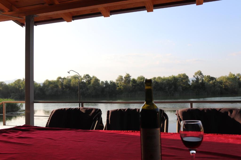 a bottle of wine sitting on a table with a glass at Holiday home Ramovic in Virpazar