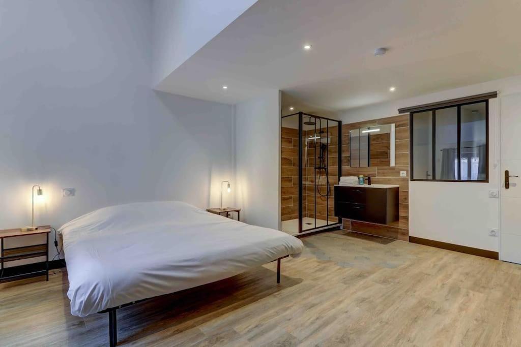 a bedroom with a large bed and a bathroom at LA MANUFACTURE - TOPDESTINATION-BOURG - Centre ville - Classé 3 étoiles in Bourg-en-Bresse