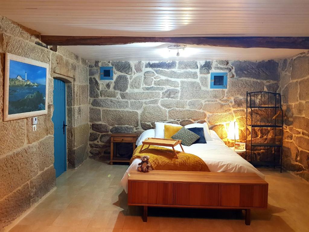 sypialnia z łóżkiem w kamiennej ścianie w obiekcie A aira da xoaniña w mieście Allariz