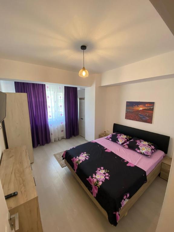 une chambre avec un grand lit avec des draps violets dans l'établissement MMA Sunset Vibes Mamaia Nord, à Mamaia Nord – Năvodari