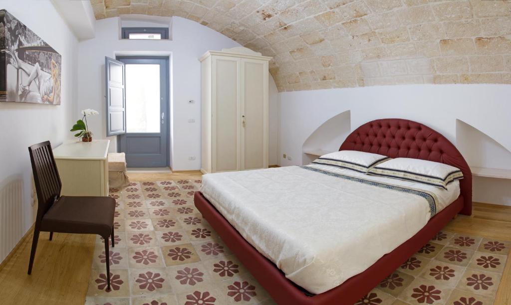 a bedroom with a large bed and a chair at Don Pedro di Toledo in Monopoli