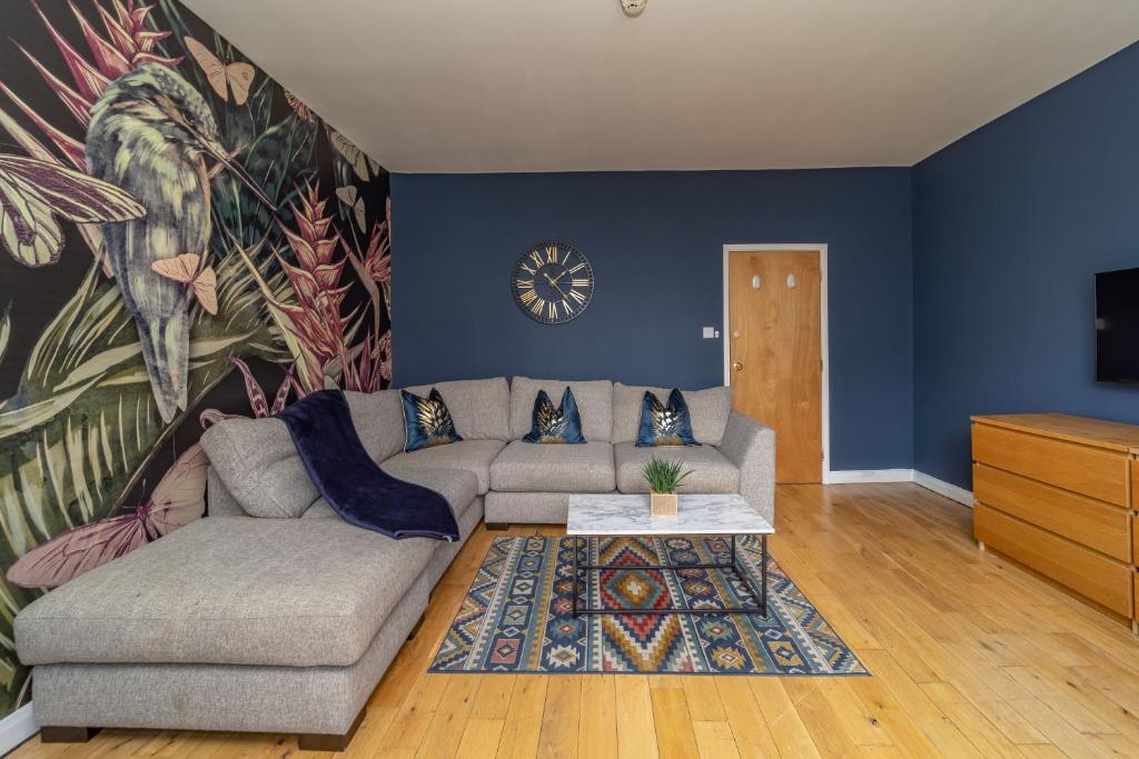 a living room with a couch and a clock on the wall at NEXT TO BRIGHTON STATION THREE BEDROOM FLAT SLEEP 10 Guests in Brighton & Hove