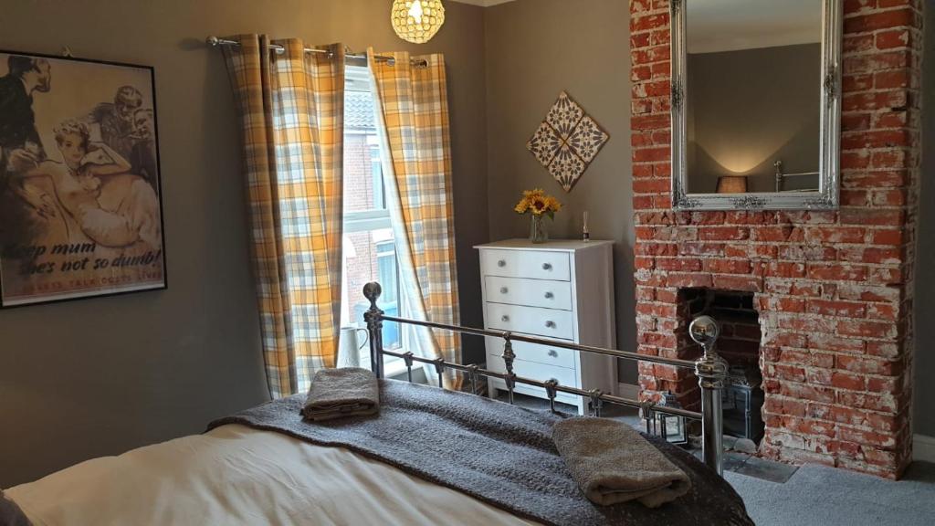 1 dormitorio con 1 cama y chimenea de ladrillo en The City Pad en Norwich